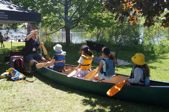 Attending the Peterborough Children's Water Festival for the first time, The Canadian Canoe Museum offered an activity centre which taught children about buoyancy and the importance of water safety. Here, children are pictured practising with paddles while wearing life jackets. (Photo: Yvonne Hollandy / GreenUP)