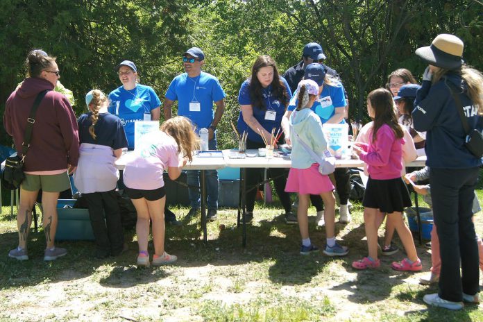 Members of GM Financial lead students in a water-drop painting activity at the 24th annual Peterborough Children's Water Festival, which invited children to express through art what water means to them. (Photo: Yvonne Hollandy / GreenUP)
