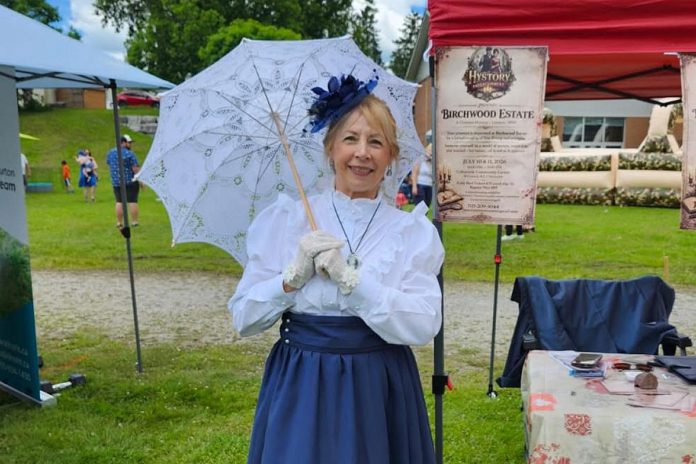 Hystory Entertainment founder Jacquie Barker at the Freshwater Summit Festival in Coboconk on June 20, 2026, promoting her debut Victorian murder mystery experience "Murder at Birchwood Estate" at the Coboconk Community Centre on July 10 and 11. The interactive event will feature a three-course meal, a silent auction, and an opportunity to learn about local history during the Victorian era. (Photo courtesy of Hystory Entertainment)