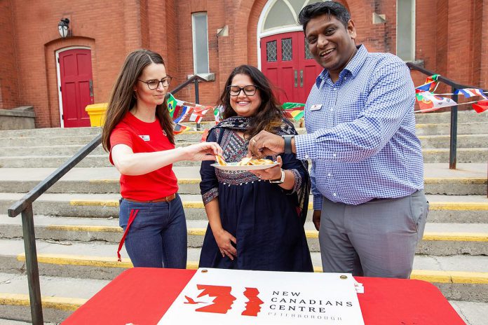 The New Canadians Centre's Director of Fundraising and Communications Katelyn Rothenbush and Executive Director Jeeniraj (JJ) Thevasagayam sample Priyanka Menghi's cilantro mint chutney during an announcement on June 10, 2026 of the non-profit organization's fifth annual Canadian Multicultural Festival, which runs from Wednesday, June 17 to Friday, June 26. The chutney is one of the dips that will be featured at the "Dip Around the World" event on Tuesday, June 23. (Photo: Jordan Lyall / kawarthaNOW)