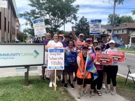 OPSEU/SEFPO Local 358 president Jessica Bushey (front left) with developmental services workers and supporters in front of the Community Living Trent Highlands office on Aylmer Street in Peterborough on June 12, 2026, as workers enter the fourth week of a province-wide strike demanding retroactive funding from the Ontario government for community and social service agencies. (Photo: Bethan Bates / kawarthaNOW)