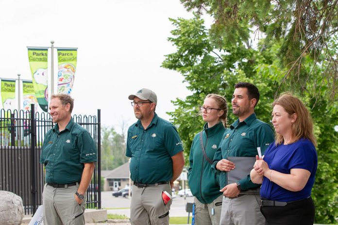 Parks Canada's manager of canal operations Chad Buchner (left) smiles during a media event on June 25, 2026 for the opening of the new Peterborough Visitor Centre as Parks Canada staff and the City of Peterborough's recreation, parks and culture service manager Cathy Mitchell (right) look on. (Photo: Jordan Lyall / kawarthaNOW)