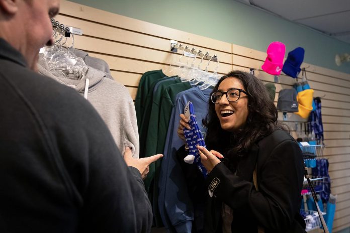 Peterborough Downtown Business Improvement Area executive director Nour Mazloum explores the gift shop at the new Peterborough Visitor Centre during a media event on June 25, 2026. (Photo: Jordan Lyall / kawarthaNOW)