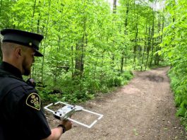 An officer with Elgin County Ontario Provincial Police (OPP) demonstrates the tracking technology used in the Project Lifesaver program, which helps searchers quickly locate people with cognitive disorders who wander. Through a collaborative partnership between local emergency services and community organizations, the internationally recognized program is coming to Kawartha Lakes in summer 2026. (Photo: OPP)