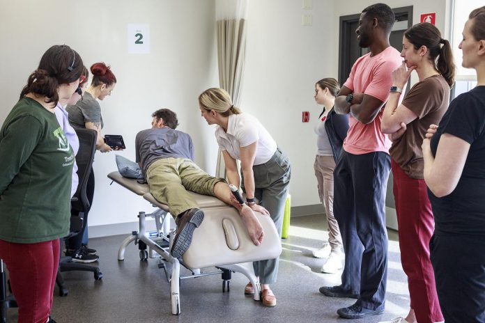 Trent Health in Motion sports medicine physician Dr. Jessica Hewitt shows her colleagues how to use a portable ultrasound unit during a team in-service, illustrating the clinic's integrated and collaborative approach with a focus on evidence-informed healthcare. Located within the Trent University Athletics Centre in Peterborough, Trent Health in Motion provides personalized care for sports rehabilitation, injury recovery, and overall wellness, with services including orthopedic physiotherapy, pelvic physiotherapy, chiropractic care, massage therapy, personal training, dietitian services, hydrotherapy, and sport medicine physician consultations. (Photo courtesy of Trent Health in Motion) Trent Health in Motion sports medicine physician Dr. Jessica Hewitt shows her colleagues how to use a portable ultrasound unit during a team in-service, illustrating the clinic's integrated and collaborative approach with a focus on evidence-informed healthcare. Located within the Trent University Athletics Centre in Peterborough, Trent Health in Motion provides personalized care for sports rehabilitation, injury recovery, and overall wellness, with services including orthopedic physiotherapy, pelvic physiotherapy, chiropractic care, massage therapy, personal training, dietitian services, hydrotherapy, and sport medicine physician consultations. (Photo courtesy of Trent Health in Motion)