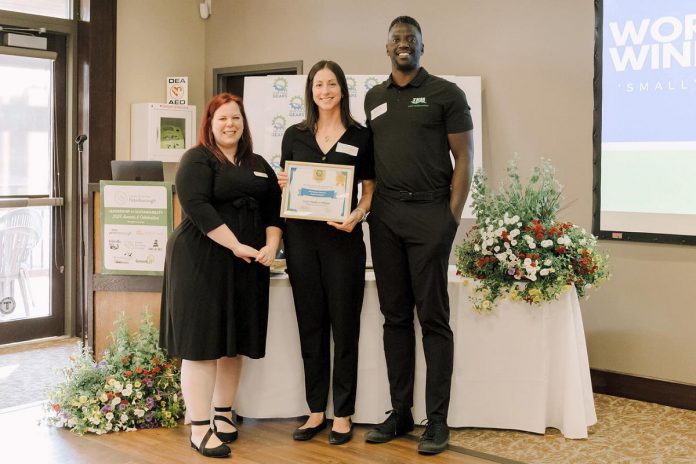 GreenUP's Education and Active Transportation Program Manager Ashley Burnie Seeds presents Trent Health in Motion co-owners Reanna Montopoli and Michael Williams with a Sustainability Leadership Award for supporting active commuting initiatives. The business annually participates in GreenUP's Shifting Gears May Challenge, is a Green Economy Peterborough member, and encourages active commutes from staff members. (Photo courtesy of Trent Health in Motion)
