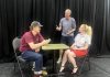Director Jack van Roosmalen (standing) with actors Eddy Sweeney and Rebecca Birrell during a rehearsal for "Photographic Memory" written by Ron Davies. The 10-minute play, about a man who finds that photos can be as hard as memories to erase after his ex asks him to delete some photos she sent him, is one of 10 plays to be staged as part of the "10 Minute Sunday" short play festival hosted by the Peterborough Theatre Guild on August 9, 2026. (Photo courtesy of D'Arcy Jenish)