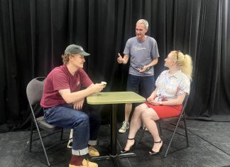 ’10 Minute Sunday’ short play festival returns to the Peterborough Theatre Guild on August 9 Director Jack van Roosmalen (standing) with actors Eddy Sweeney and Rebecca Birrell during a rehearsal for "Photographic Memory" written by Ron Davies. The 10-minute play, about a man who finds that photos can be as hard as memories to erase after his ex asks him to delete some photos she sent him, is one of 10 plays to be staged as part of the "10 Minute Sunday" short play festival hosted by the Peterborough Theatre Guild on August 9, 2026. (Photo courtesy of D'Arcy Jenish)