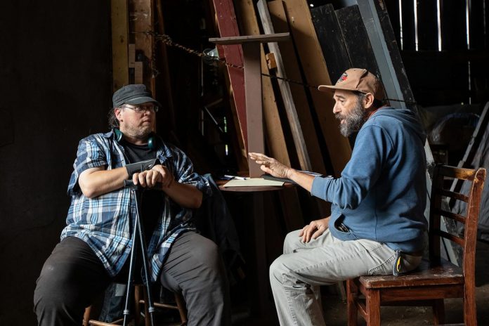 "Wild Irish Geese" musical director and composer Justin Hiscox (left) and musician Jason Edmunds discuss the music in "Wild Irish Geese" during a media day event at 4th Line Theatre in Millbrook on July 22, 2026. Megan Murphy's play about the Peter Robinson emigration returns to the Winslow Farm from August 4 to 29 after its sold-out world premiere last summer. (Photo: Jordan Lyall / kawarthaNOW)