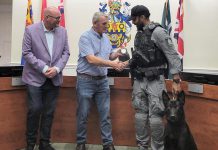 Cobourg police service board chair Adam Bureau (left) and retired sergeant Don Missen, who led the Cobourg police's former canine unit from 1997 to 2003, presented Constable Amrit Gill and German shepherd Atos with the K-9 badge at a ceremony during the police service board's meeting in council chambers at Victoria Hall on July 28, 2026. (Photo courtesy of Cobourg Police Service)
