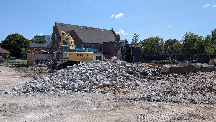 A view of the west side of Mark Street United Church at 90 Hunter Street East in Peterborough's East City as demolition continues of the church's former Christian Education Centre, the site of TVM Group's new 17-storey high-rise apartment building, on July 23, 2026. (Photo: Bruce Head / kawarthaNOW)