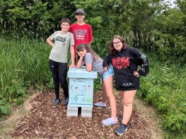 The youth team behind Empire Beez in Trent Hills (left to right: Sebastian Smith, Owen Musson, Eloise Smith, and Penelope McEvoy) stand with the beehive they installed at the Simpson Street Community Garden in Campbellford. The group launched the small business last year with the aim of raising awareness around honeybees and installing community beehives. The team will be unveiling the beehive during a garden talk held by IncrEdible Trent Hills on July 9, 2026. (Photo courtesy of Blythe Weber)