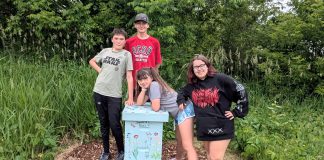 The youth team behind Empire Beez in Trent Hills (left to right: Sebastian Smith, Owen Musson, Eloise Smith, and Penelope McEvoy) stand with the beehive they installed at the Simpson Street Community Garden in Campbellford. The group launched the small business last year with the aim of raising awareness around honeybees and installing community beehives. The team will be unveiling the beehive during a garden talk held by IncrEdible Trent Hills on July 9, 2026. (Photo courtesy of Blythe Weber)