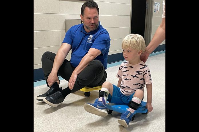 Five Counties Children's Centre CEO Scott Pepin races client Hamish down the hall after he completed one of his recent treatment sessions at the Peterborough-based children's treatment centre. (Photo courtesy of Five Counties Children's Centre)