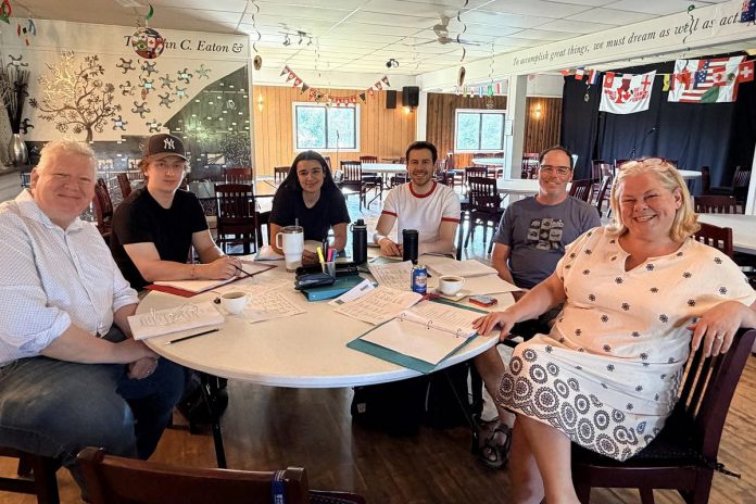 Globus Theatre's artistic producer James Barrett (left) and artistic director Sarah Quick (right) during the first day of rehearsals for the world premiere of Bradley Austin's "Sore Losers" from July 15 to 25, 2026. Along with Barrett performing as Jim, Austin (second from right) will play Burt, Kyle Claeys (beside Austin) will play Greg, and Mallory Brumm (beside Claeys) will play Angie. (Photo: Globus Theatre / Facebook)