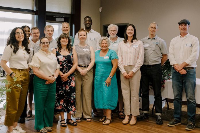 With the help of Nour Mazloum of the Peterborough Downtown Business Improvement Area and Rhonda Keenan of Peterborough County (front left), Green Economy Peterborough's fifth annual Leadership in Sustainability Celebration on June 11, 2026 recognized its Sustainability Catalysts of 2026: Sullivan Law, Peterborough Optometric, Camp Kawartha, Engage Engineering, Jigsaw Organizing Solutions, Wild Rock Outfitters, Trent Health in Motion, Generation Solar, Morton Medical Centre, and Woodleigh Farms. Not pictured: Basterfield & Associates, Cabinetree, Cambium Consulting + Engineering, Green Street, Unity Design Studio, and John Cunningham. (Photo: Heather Doughty)