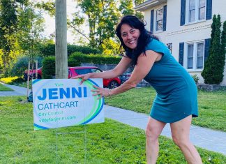 Jenni Cathcart, one of four candidates vying for two Town Ward seats on Peterborough city council in the October municipal election, placing an election lawn sign. The first-time candidate tells kawarthaNOW that three of her election signs, including one on the lawn of her own Homewood Avenue home, were taken by someone in the middle of the day on July 20, 2026. (Photo courtesy of Jenni Cathcart campaign)