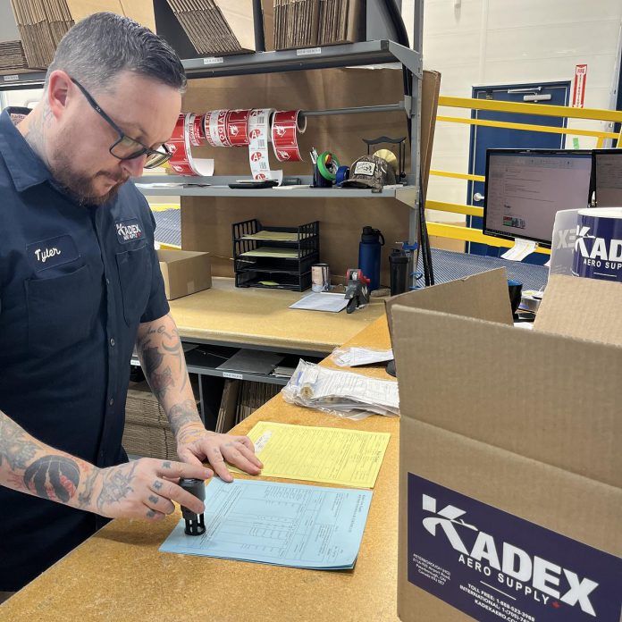 KADEX Aero Supply employee Tyler Primeau uses one of the new workspaces at the company's recently expanded and renovated warehouse at the Peterborough Airport. The individualized workspaces improve workflow by ensuring staff members are not waiting on a station and computer to do their work. The close proximity additionally makes it easier to call out urgent orders and ensure streamlined communications between team members. (Photo courtesy of KADEX Aero Supply)