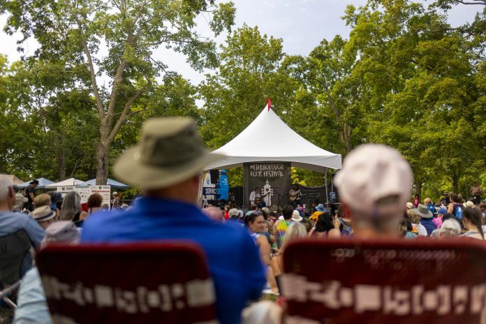 Audience members enjoy a free performance at the 2025 Peterborough Folk Festival in Nicholls Oval Park. (Photo: Michael Hurcomb)