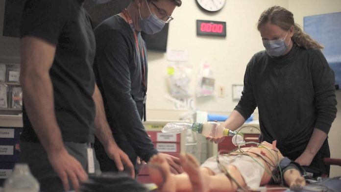Dr. Sarah Foohey leads simulation training for the Emergency Department team at Peterborough Regional Health Centre (PRHC) using a pediatric mannequin. Without a state-of-the-art simulation mannequin, trainees have to ask trainers to describe changes in the simulated patient, such as if they are breathing, what their blood pressure is, and whether their pupils are dilated. Having a mannequin that presents changing vital signs on its own in real time will allow the team to remain present in the simulation from start to finish, more closely matching a true-life scenario. (Photo courtesy of PRHC Foundation)