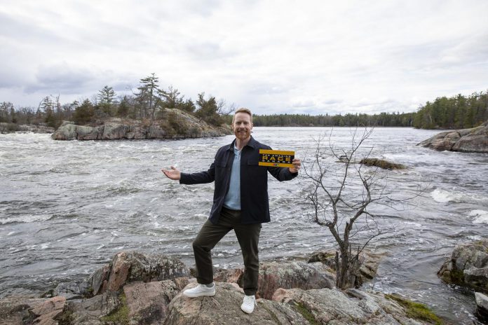 The Amazing Race Canada host Jon Montgomery stands at what appears to be Burleigh Falls in Peterborough County. Montgomery has hosted all previous seasons of the show and has earned two Canadian Screen Awards. He is a skeleton racer who won gold during the Winter Olympics in Vancouver 2010. (Photo: Bell Media)