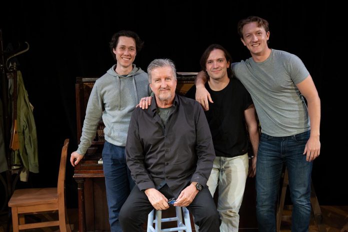 "And No Birds Sang" playwright Dave Carley (seated) with (from left) actors Aaron Macpherson, Daniel Reale, and Mayson Sonntag. Macpherson plays a young Farley Mowat while Reale and Sonntag play around 20 roles as well as perform sound effects for the play, which premieres at the Capitol Theatre's Sculthorpe Theatre in Port Hope, running for 27 performances from August 14 to September 6, 2026. (Photo: Sam Moffatt)