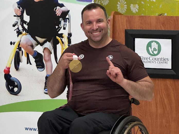 Wheelchair curler Jon Thurston displays his gold medal from the Milano Cortina 2026 Paralympic Games at the 50th annual meeting of Five Counties Children's Centre on June 22, 2026. (Photo courtesy of Five Counties Children's Centre)