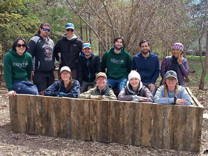Trent University learning garden teacher candidates, including Janelle Wiens (front, second from left), were asked to repurpose wood salvaged from an old lathhouse to create a pool surround for aquatic plants at GreenUP Ecology Park Native Plant Nursery. In small groups, the learning garden participants made their plans then reconvened to combine their concepts into a final design. Pictured is what they accomplished in just one day, with everyone contributing and having fun at the same time. (Photo: Christina Balint / GreenUP)