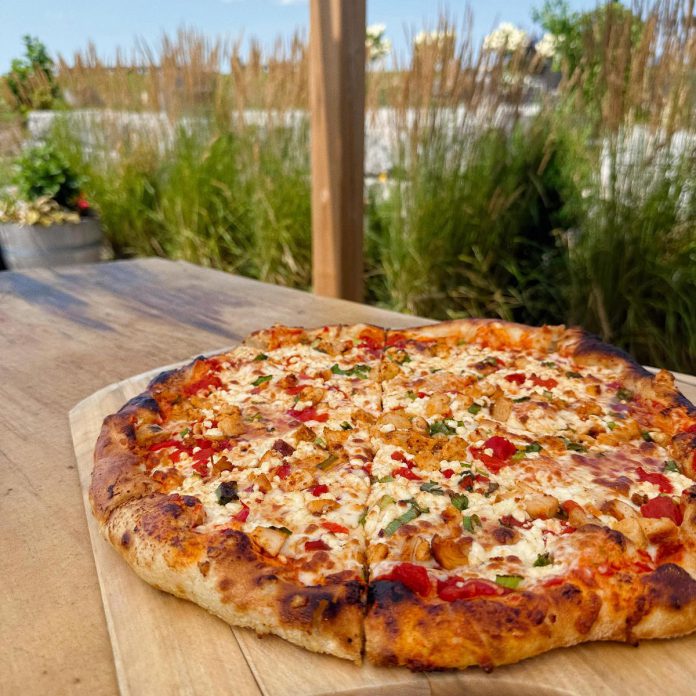 At Rolling Grape Vineyard in Bailieboro, you can enjoy views of the 150-acre family farm while sipping on local wine, listening to live music, and enjoying wood-fired pizza. Rolling Grape is constantly releasing new pizzas seasonally and ensures they cater to diners by serving gluten-free crusts and dairy-free cheese. (Photo courtesy of Rolling Grape Vineyard)