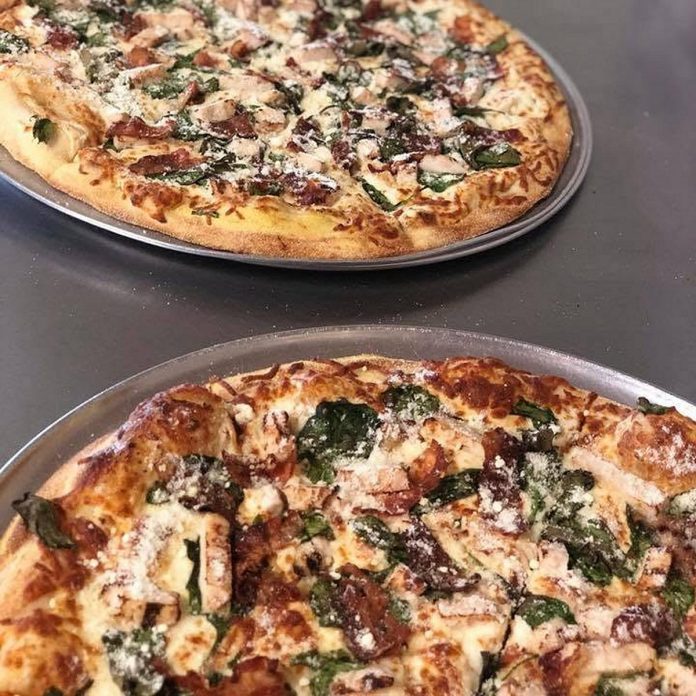 With a reputation that precedes itself, the Mighty Caesar specialty pizza at Pizza Alloro in Buckhorn is topped in a creamy Caesar dressing, mozzarella, chicken, spinach, bacon, and parmesan cheese. Owner Endrit Karaj will be opening Buckhorn Burger Company behind Pizza Alloro in early 2027. (Photo courtesy of Pizza Alloro)