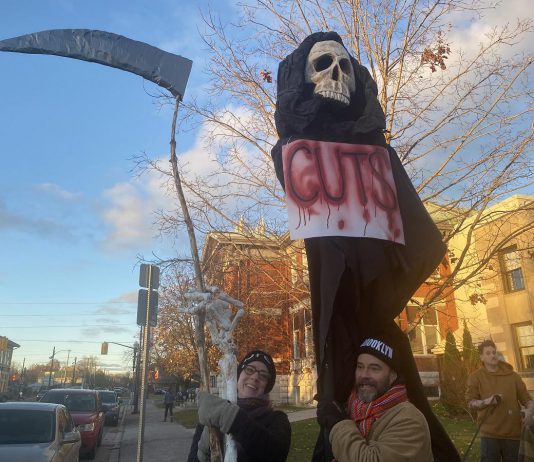 Supporters of local arts and social services organizations gathered outside Peterborough City Hall on November 12, 2024 to protest a proposed 25 per cent across-the-board cut in the City of Peterborough's 2025 draft budget to grants to community organizations. Following strong community opposition, city council ultimately voted against the cuts. (Photo: Paul Rellinger / kawarthaNOW)
