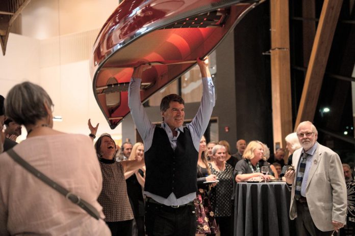 Bill Swift, owner and manager of Swift Canoe & Kayak, carries a canoe that sold for $5,000 during the live auction at the 2025 Lakeside Gala at The Canadian Canoe Museum in Peterborough. The company will once again be donating a canoe for the 2026 Lakeside Gala on Saturday, October 3, one of many donated items that will be available for bidding during the live and silent auctions to raise funds supporting the Museum's core programming. (Photo courtesy of The Canadian Canoe Museum)