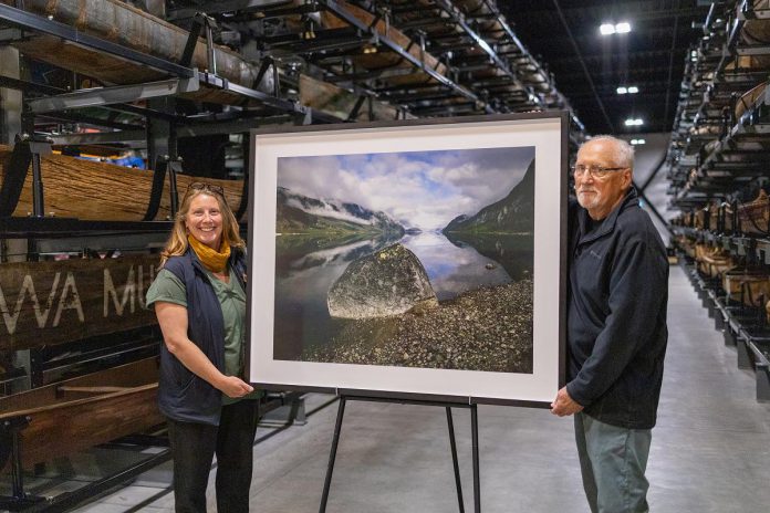 Peterborough artist Arnold Zageris gives The Canadian Canoe Museum's Executive Director Carolyn Hyslop one of his large-format photographs to be auctioned off during the Museum's annual Lakeside Gala fundraiser on October 3, 2026. (Photo courtesy of The Canadian Canoe Museum)