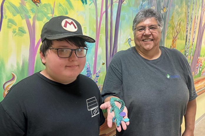 11-year-old Wyatt Robertson of Cobourg, a client of Five Counties Children's Centre, with happy customer Yvette Virgin, who holds an articulated animal that Wyatt made through his fledging 3D printing business called Prints Charming. (Photo courtesy of Five Counties Children's Centre)