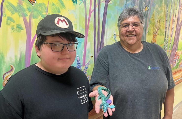11-year-old Wyatt Robertson of Cobourg, a client of Five Counties Children's Centre, with happy customer Yvette Virgin, who holds an articulated animal that Wyatt made through his fledging 3D printing business called Prints Charming. (Photo courtesy of Five Counties Children's Centre)