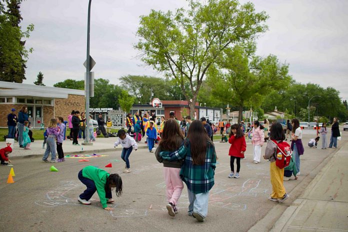 A school street pop-up created a car-free block where kids could play and create chalk art in front of St. Leo Catholic Elementary School in Edmonton one day in spring 2026. (Photo: Nicole Roach / Green Communities Canada)