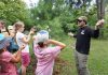 GreenUP Ecology Park program coordinator Jonathan Armstrong showed participants how to determine the age of a pine tree during a tree tour he led on Family Night at the park on Peterborough on August 27, 2026. (Photo: Alex Karn / GreenUP)