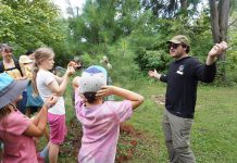 GreenUP Ecology Park program coordinator Jonathan Armstrong showed participants how to determine the age of a pine tree during a tree tour he led on Family Night at the park on Peterborough on August 27, 2026. (Photo: Alex Karn / GreenUP)