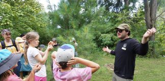 GreenUP Ecology Park program coordinator Jonathan Armstrong showed participants how to determine the age of a pine tree during a tree tour he led on Family Night at the park on Peterborough on August 27, 2026. (Photo: Alex Karn / GreenUP)