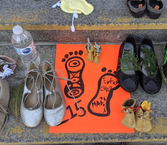 Children's shoes, toys, and offerings on the steps of Peterborough City Hall in June 2021 as part of a community memorial created in response to the discovery of the remains of 215 Indigenous children buried at the former Kamloops Indian Residential School in British Columbia. As well as remembering and honouring those lost to residential schools and the thousands of survivors, National Day for Truth and Reconciliation is a day for Canadians to educate themselves about the heritage, culture, stories, and experiences of First Nations, Inuit, and Métis peoples. (Photo: Bruce Head / kawarthaNOW)