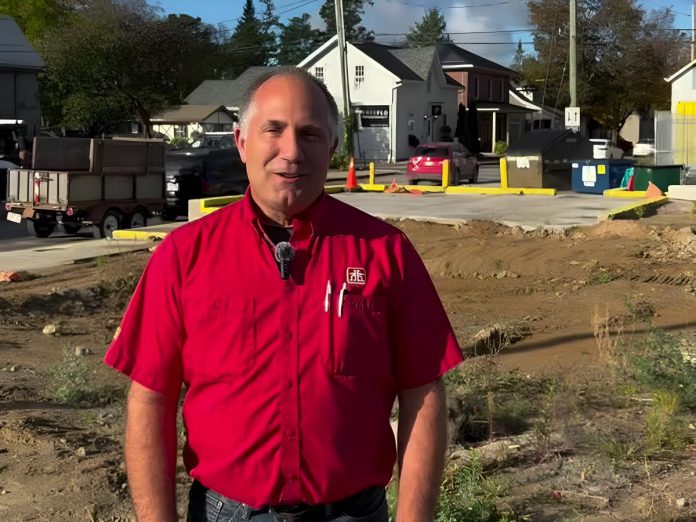 Kawartha Home Hardware general manager Garnet Hinds at the site of the former historic Kawartha Home Hardware building at 24 Queen Street in downtown Lakefield, which was demolished after being severely damaged in a fire on October 9, 2025. In a video posted on social media on October 8, 2026, Hinds says construction on a new building is ready to proceed. (kawarthaNOW screenshot)