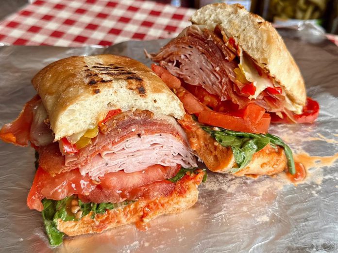One of the most popular sandwiches at The Grape and Wedge, an artisan and gourmet food shop in Apsley, is the Italian Stallion. This sandwich is stacked with four Italian deli meats, hot peppers, provolone cheese, lettuce, tomatoes, and the housemade sun-dried tomato mayonnaise on a ciabatta bun. The Grape and Wedge serves additional signatures and rotating specials and can accommodate allergies and dietary restrictions across sandwiches. (Photo courtesy of The Grape and Wedge