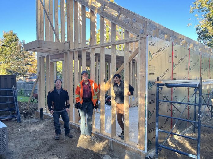 Keith Dalton (middle) of Peterborough Action for Tiny Homes (PATH) in 2024, working on the site of an additional rental unit located in the backyard of a west-end property owned by One City Peterborough. (Photo courtesy of One City Peterborough)