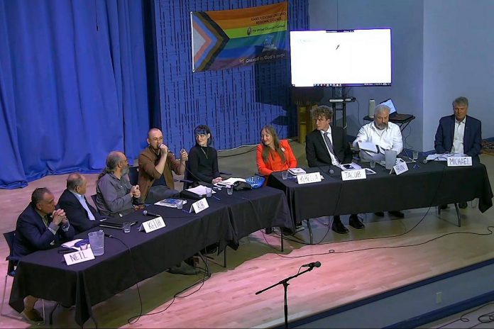 With moderator Jazmine Raine to his left, moderator Collin Chepeka addresses the audience at the end of a community discussion at New Canadians Centre on October 7, 2026 that saw a series of questions posed to Peterborough's seven mayoral candidates (from left to right): Neil Morton, Keith Riel, Rob Hailman, Rebecca Schillemat, Jacob Méthot, Brian Lumsden, and Michael Eamon. (kawarthaNOW screenshot of livestream)