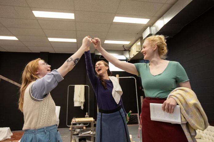 Actors Emily Kelly, Laura Lawson, and Rebecca Birrell during a rehearsal of Vern Thiessen's drama "Bluebirds," which runs at the Peterborough Theatre Guild for 10 performances from October 30 to November 14, 2026. Given the play's sometimes heavy subject matter, director Bea Quarrie says it was important to remind the actors not to let themselves be weighed down by the darkness. (Photo: Jordan Lyall)